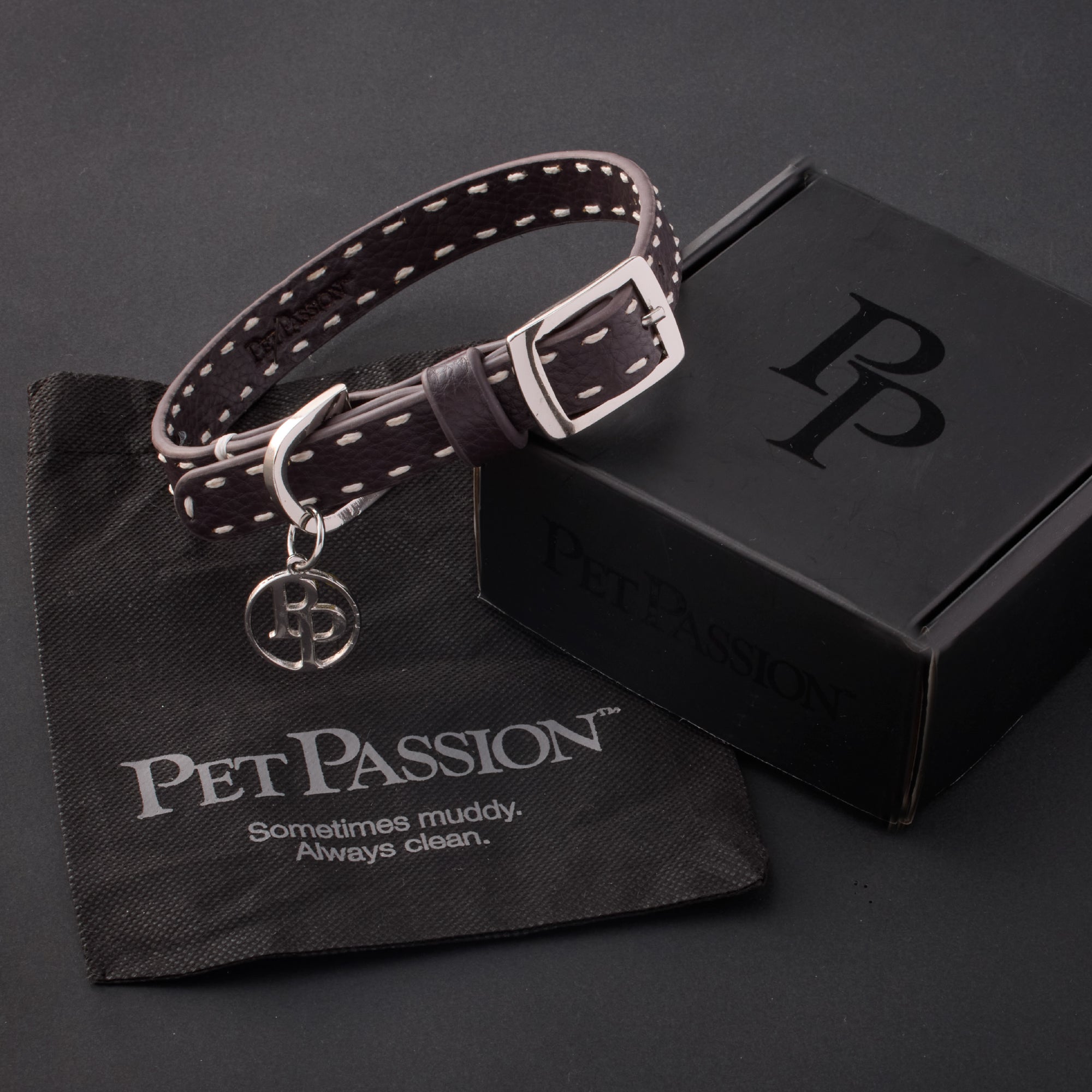 Rein collar in Chocolate Espresso with it's garment bag and packaging box, labeled with the Pet Passion logo and slogan, all on a black background