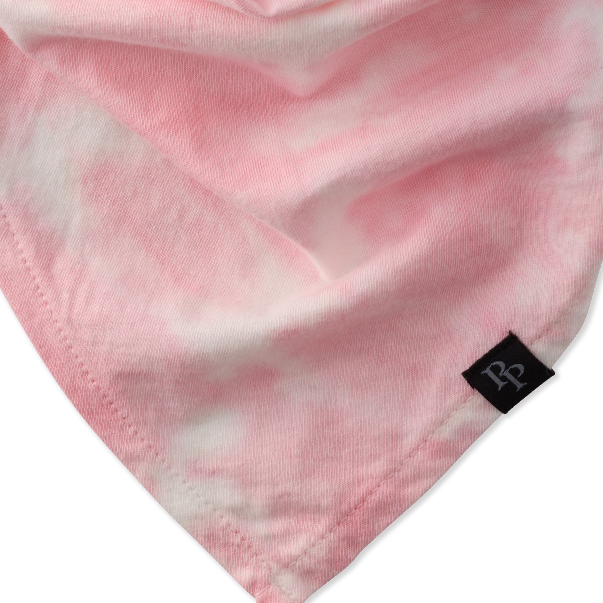 Close-up of pink fabric with a brand label on a white background