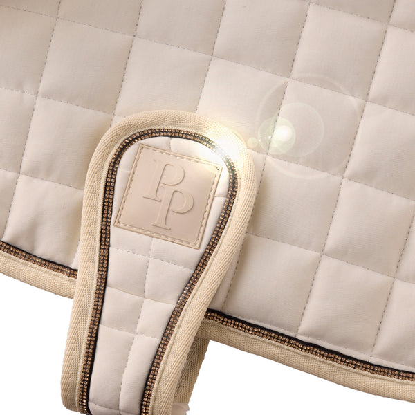 Close-up of a quilted saddle pad with a brand logo on a white background
