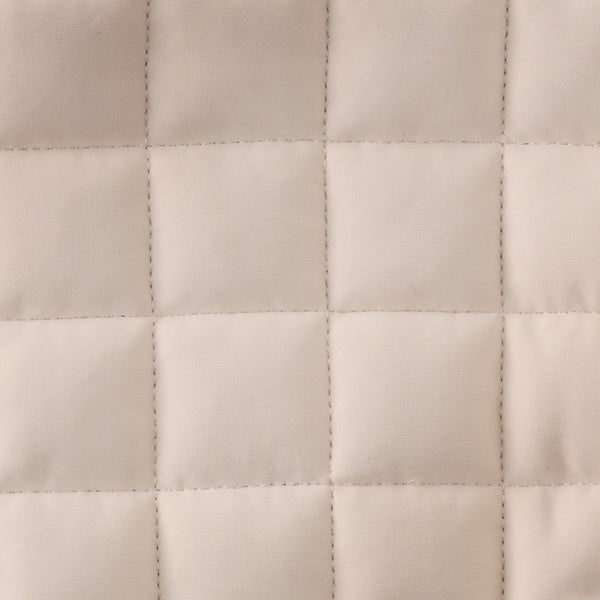 Close-up of a quilted beige fabric texture