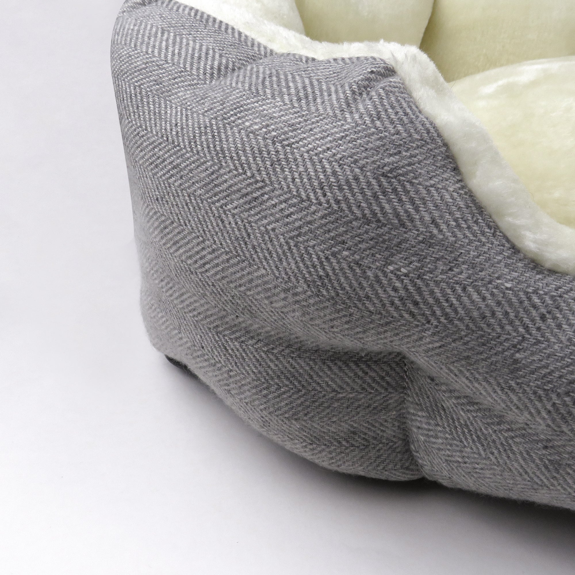 Up close of Ivory Herringbone pattern texture and fuzzy bed interior