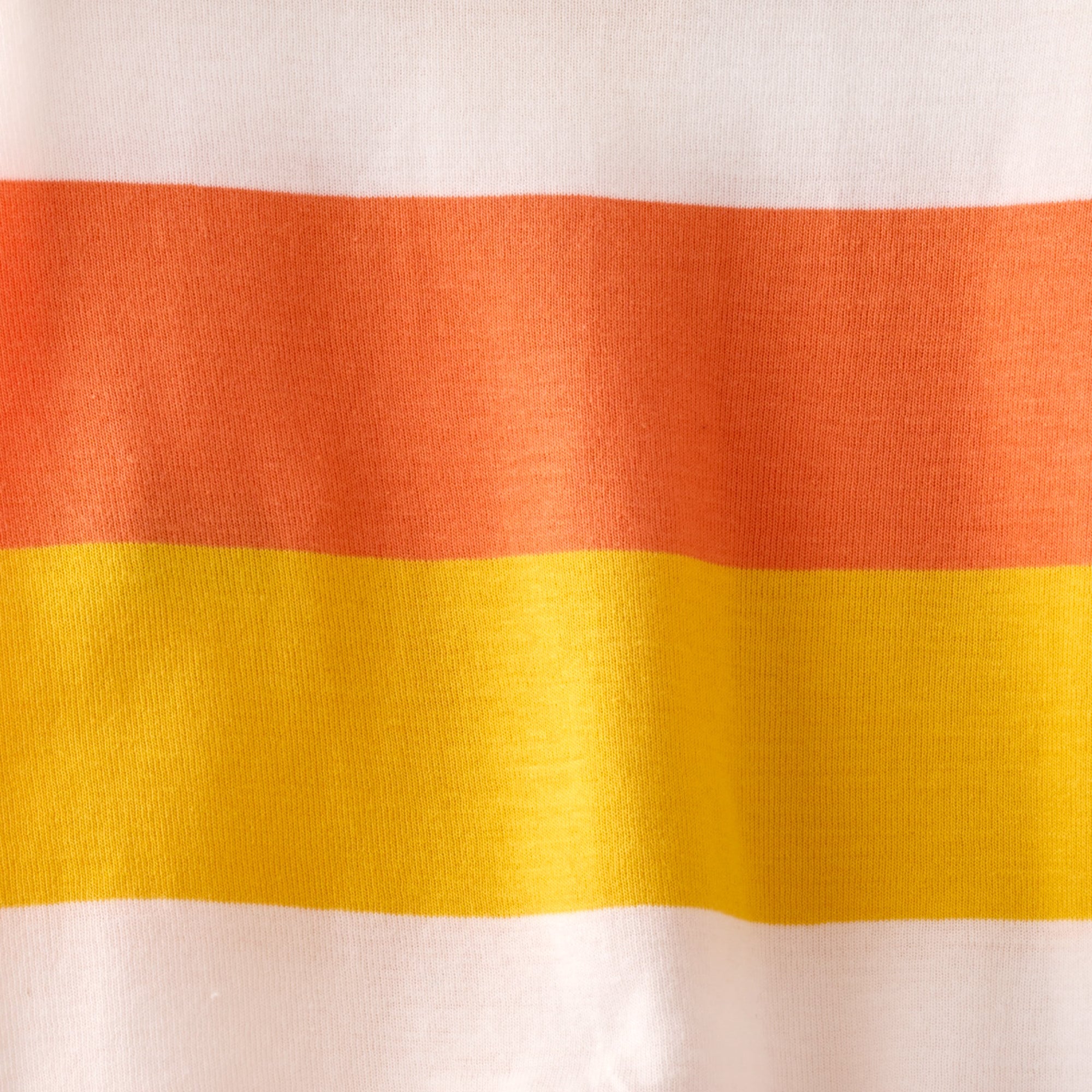 Close-up of fabric with red and yellow horizontal stripes on a white background