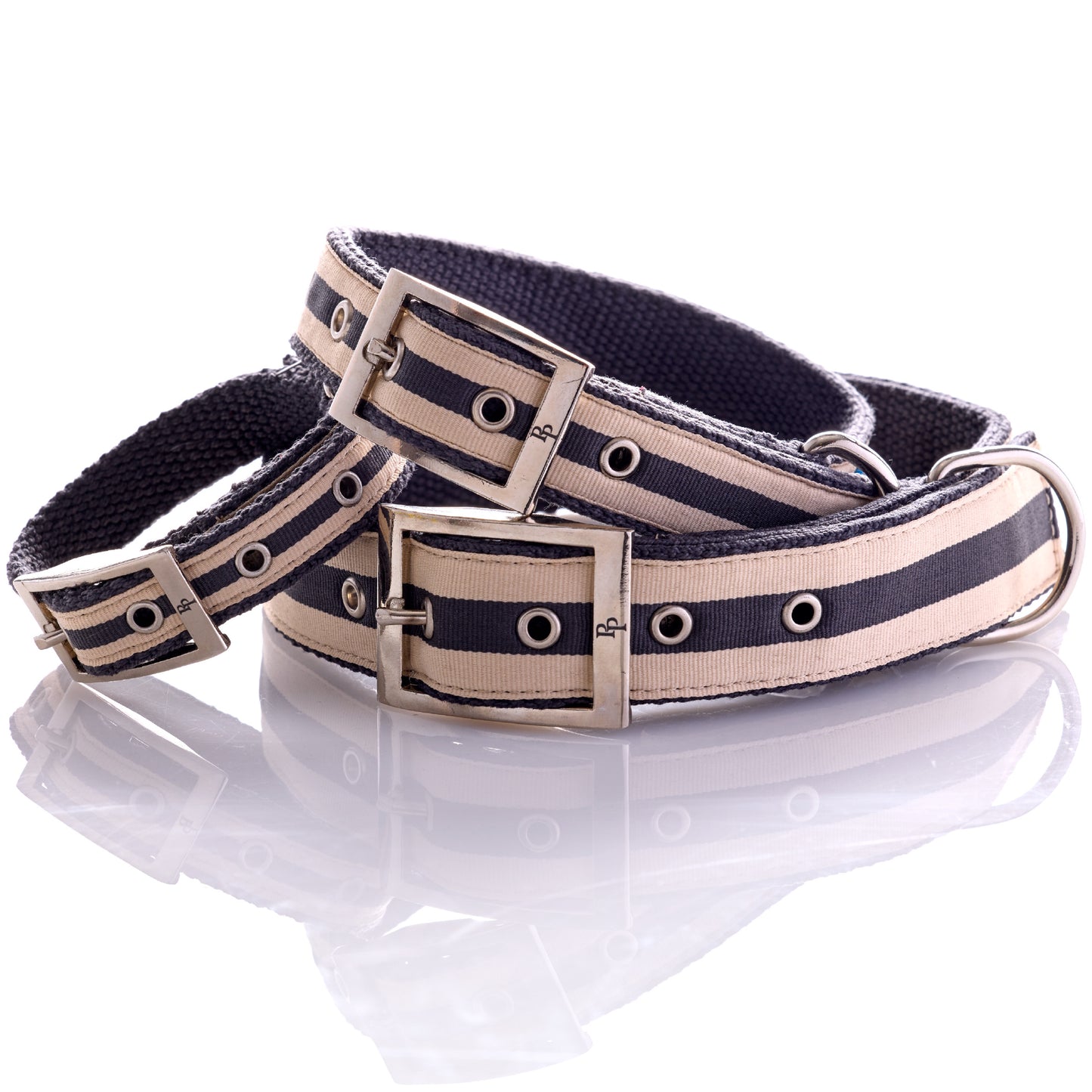 Stack of different sized black and beige collars on a white background