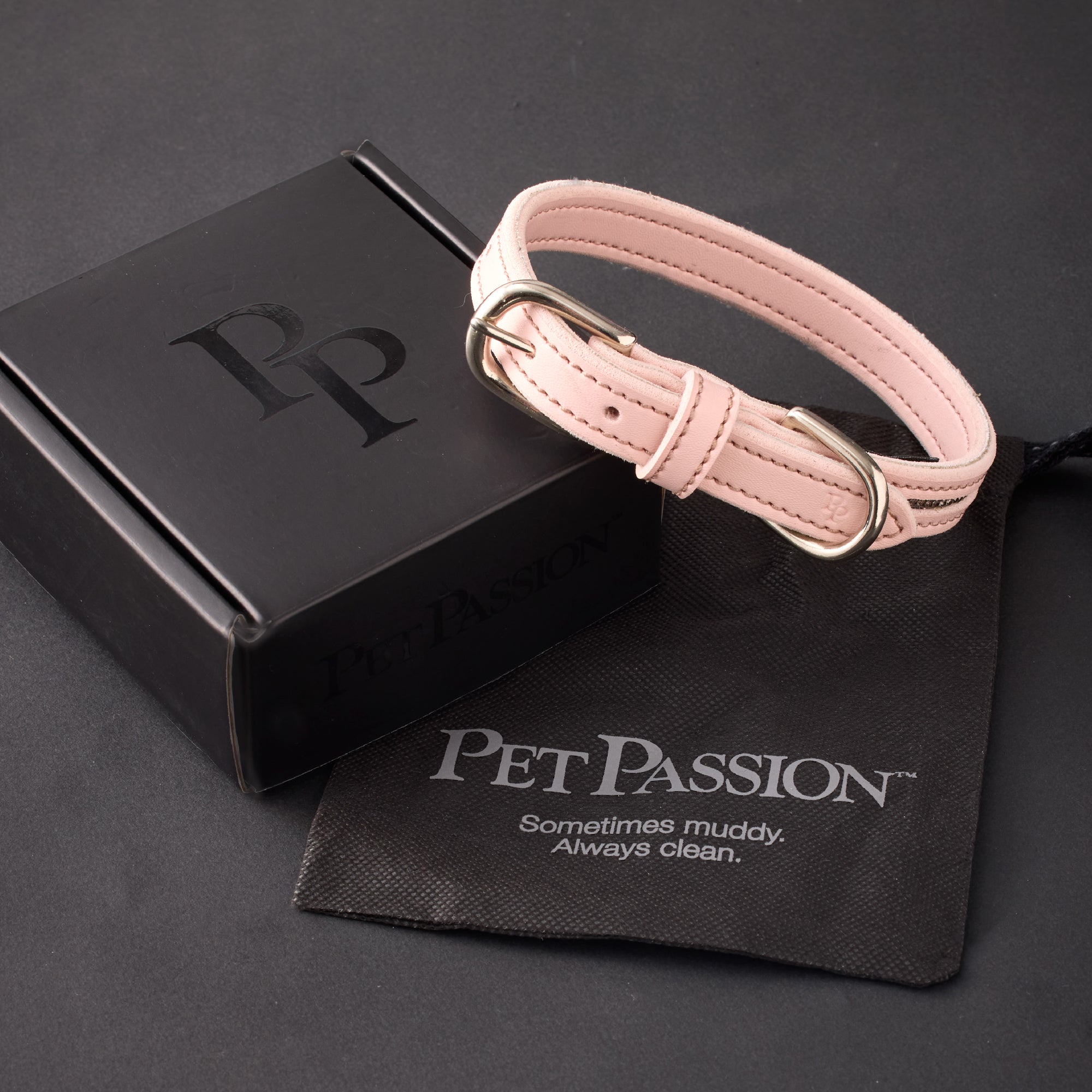 Pink dog collar with black box and pouch on a dark background, featuring 'Pet Passion' branding.