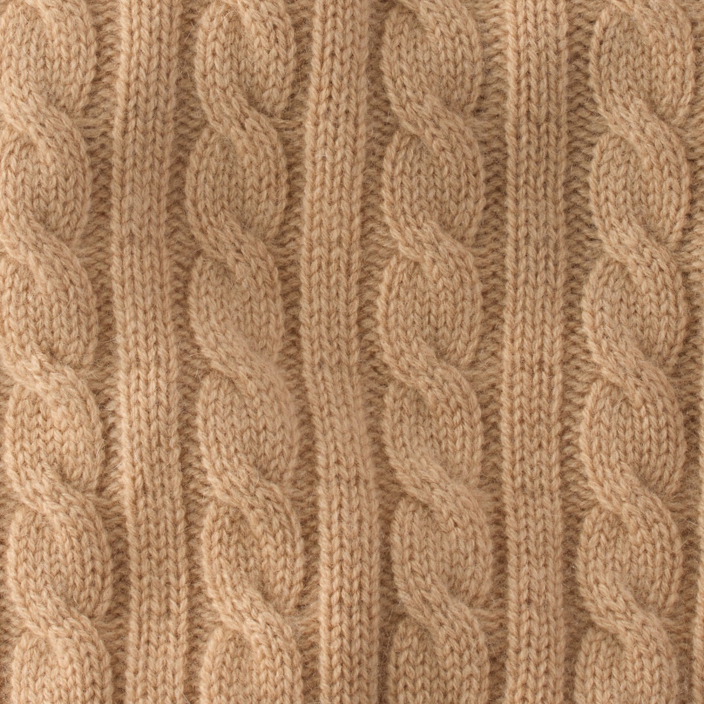 Close-up of beige knitted fabric with cable pattern