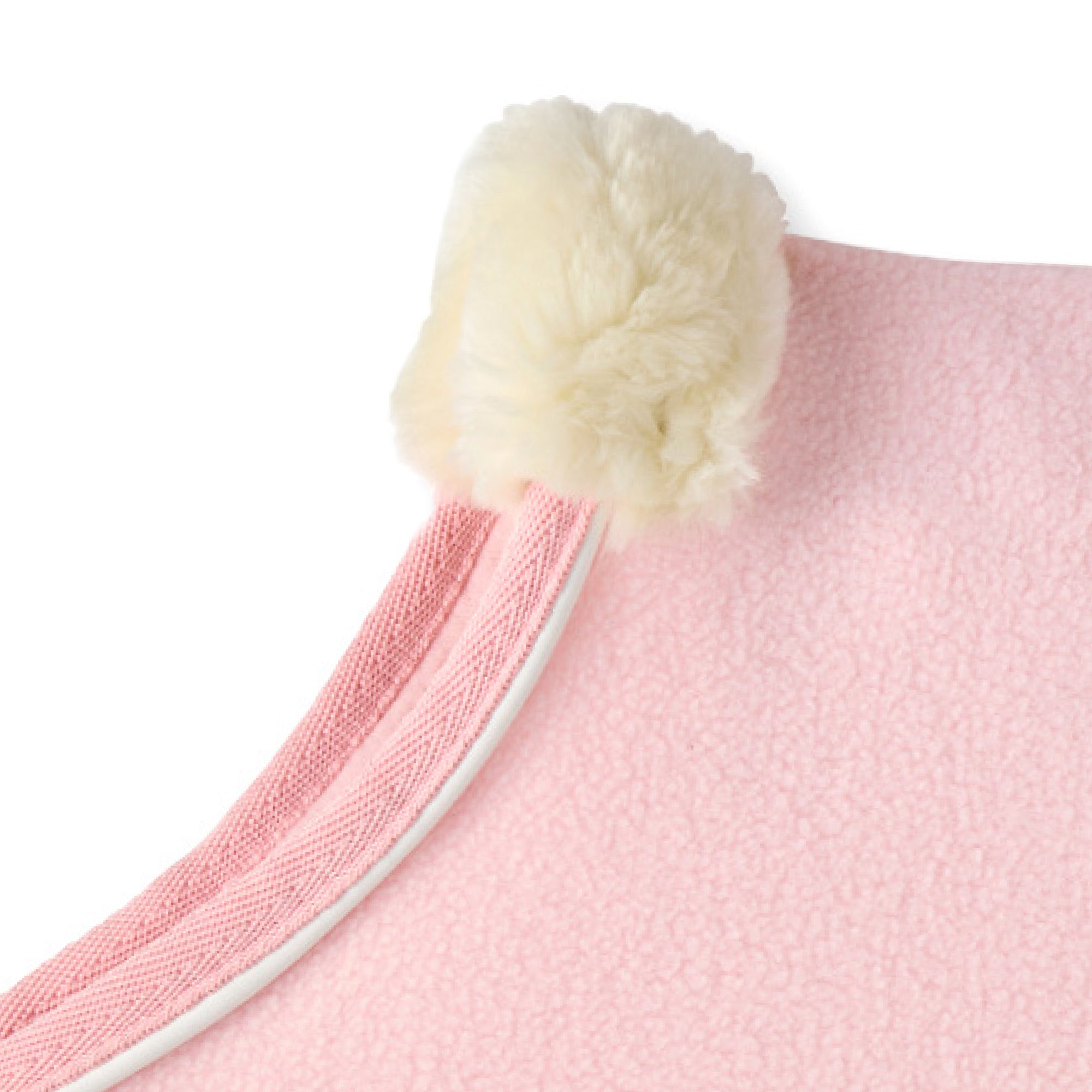 Close-up of a pink dog coat with a white pom-pom on a white background