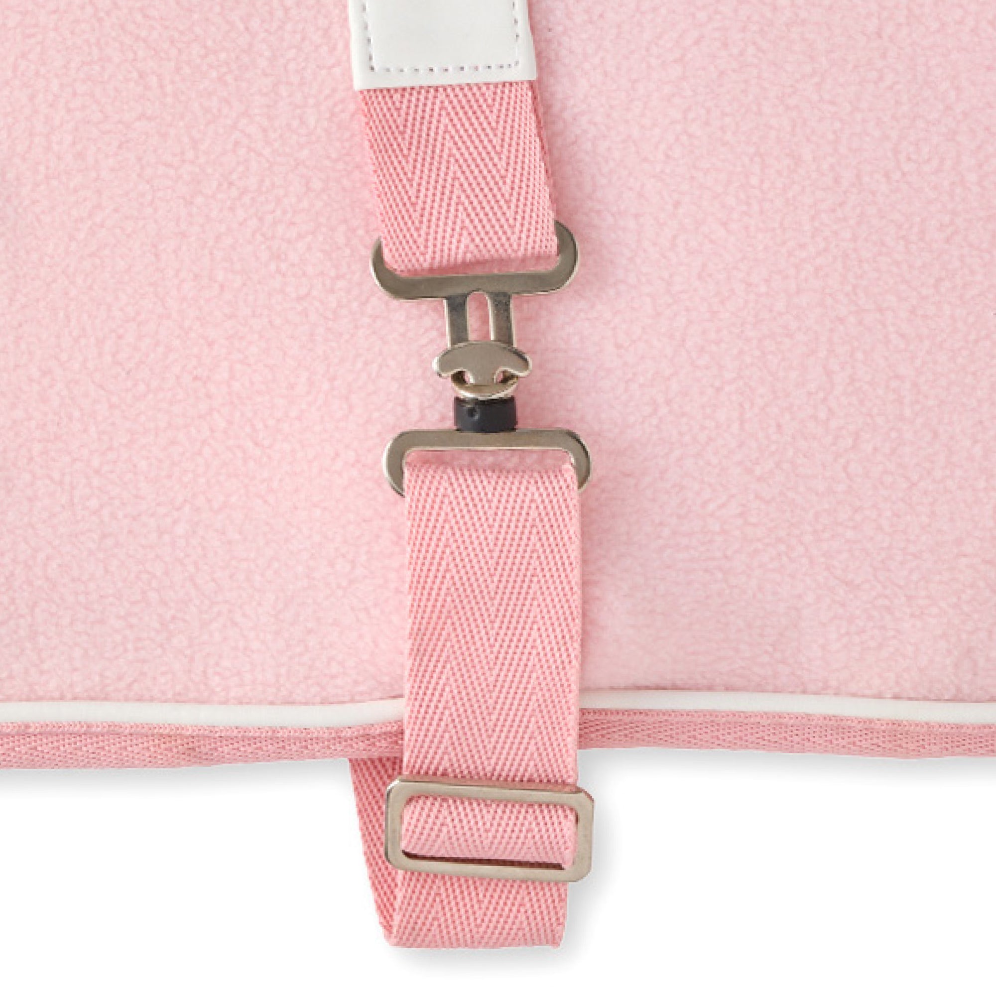 Close-up of a pink dog coat with a strap and metal buckle on a white background
