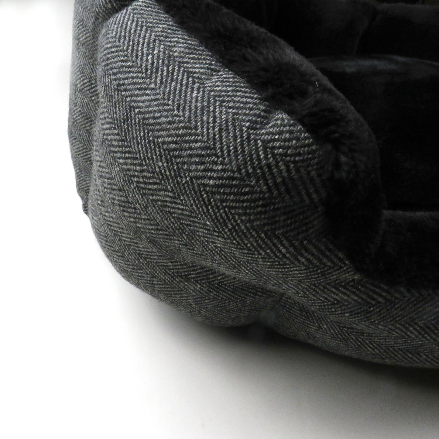 Up close of Charcoal Herringbone pattern texture and fuzzy bed interior 