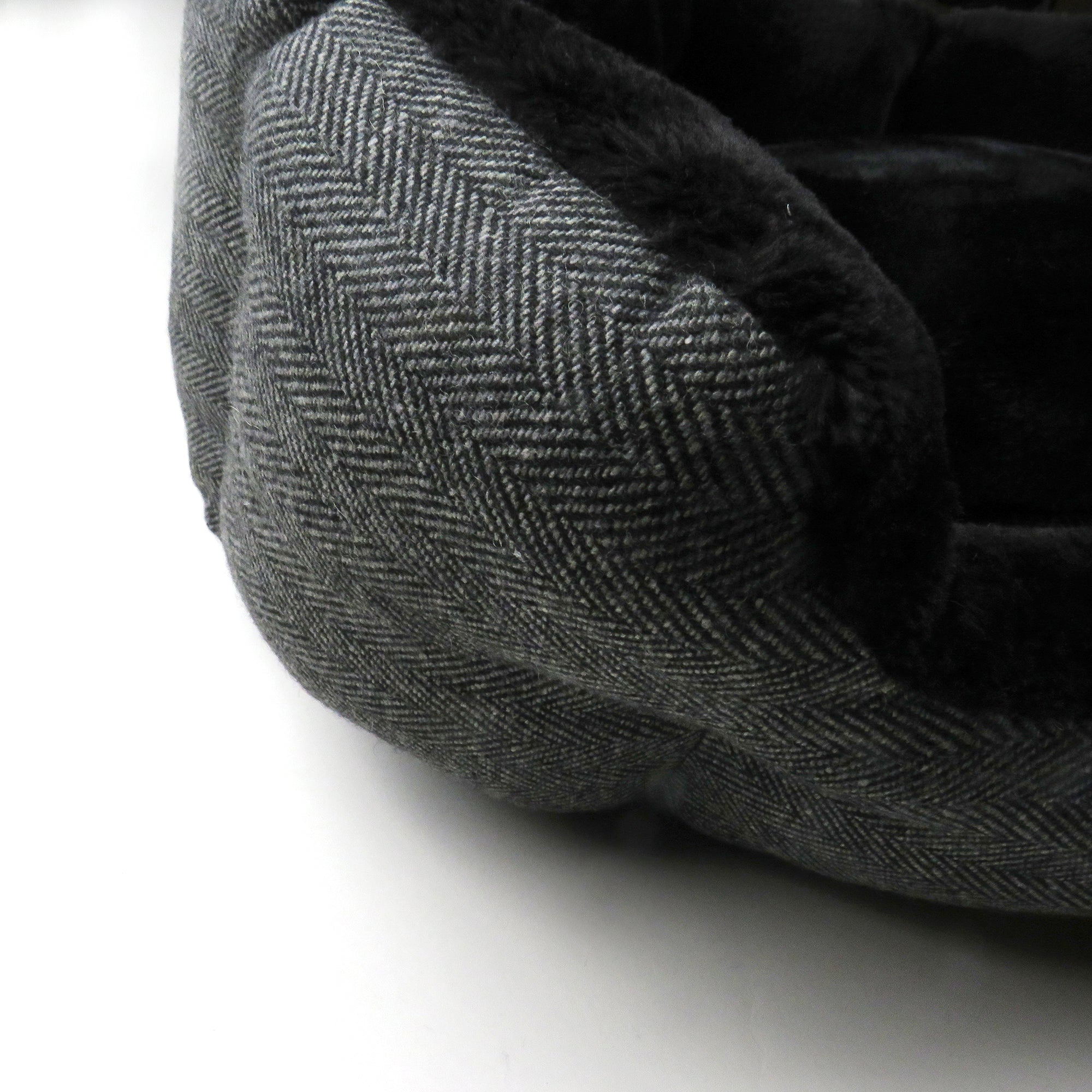 Up close of Charcoal Herringbone pattern texture and fuzzy bed interior 