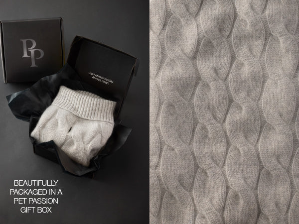 Gray knitted pet sweater in a black gift box with 'PP' branding, next to textured gray fabric.